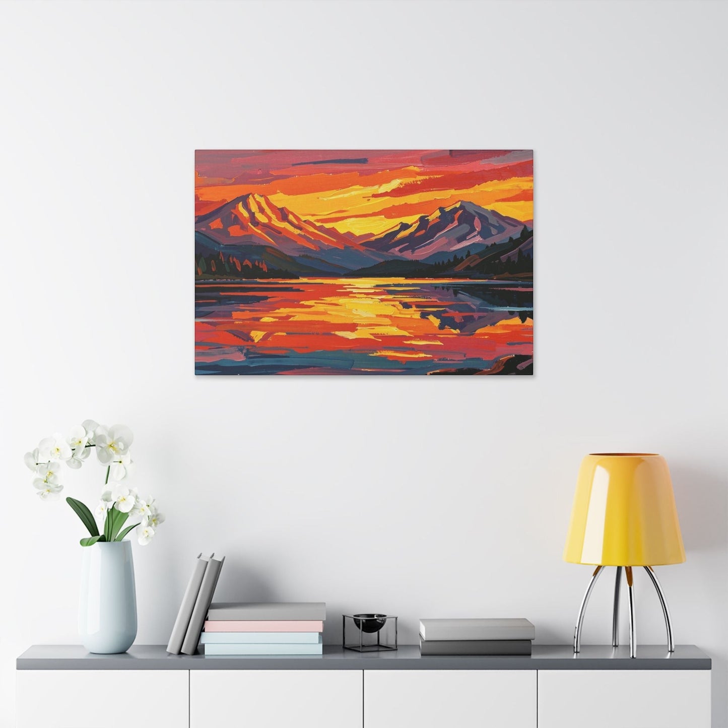 Chromatic sunset mountain lake canvas print with vibrant orange and indigo brushstrokes hanging on a white wall.