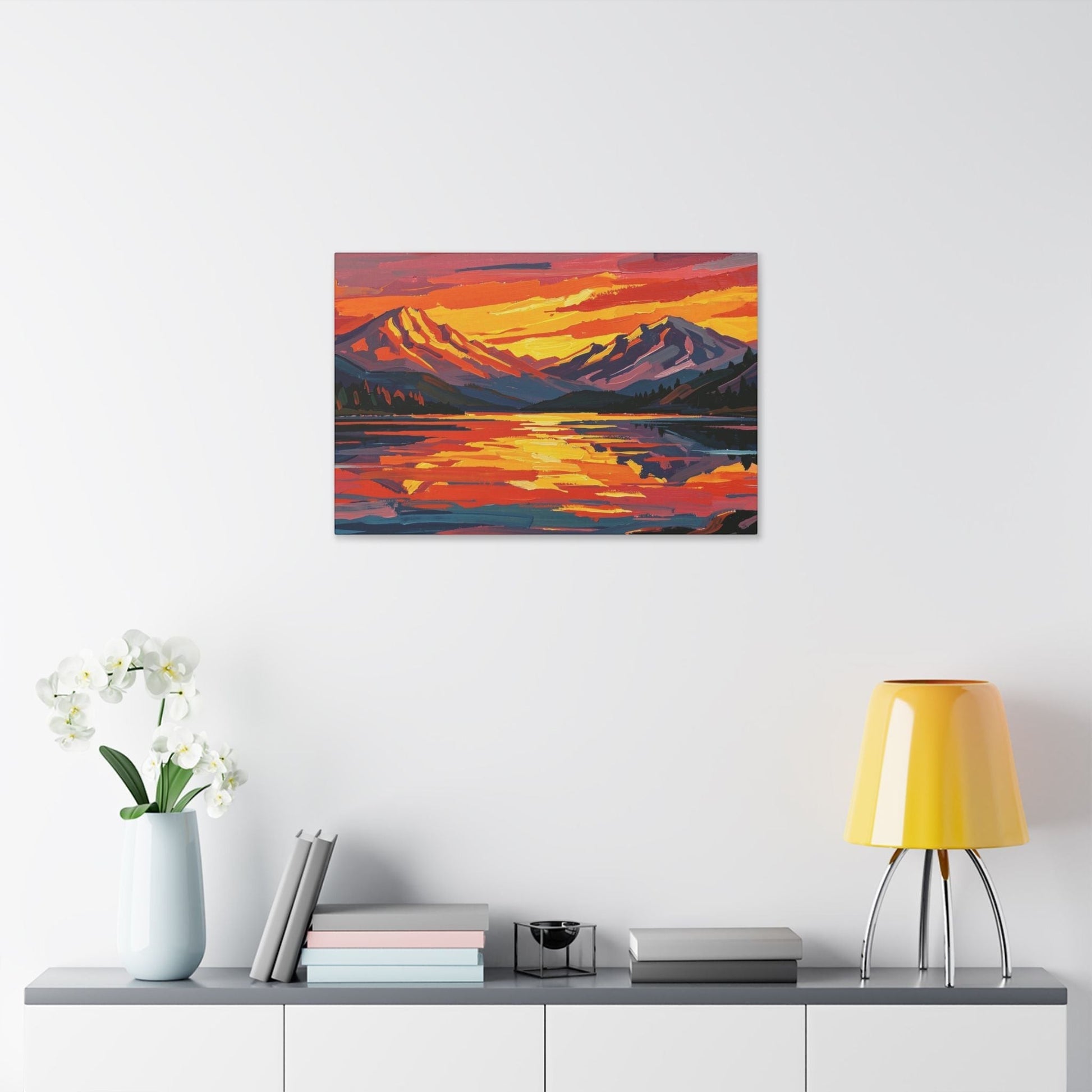 Chromatic sunset mountain lake canvas print with vibrant orange and indigo brushstrokes hanging on a white wall.