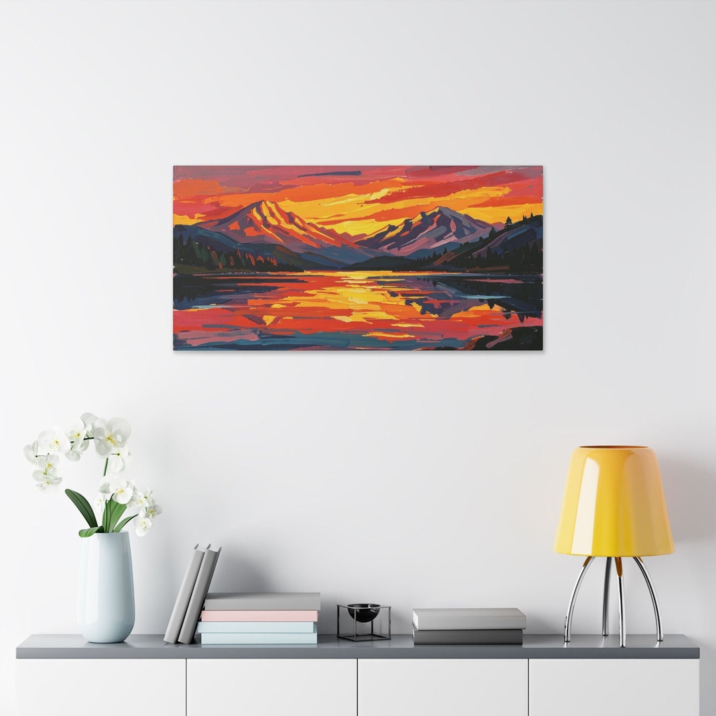 Chromatic sunset mountain lake canvas print with vibrant orange and indigo brushstrokes hanging on a white wall.