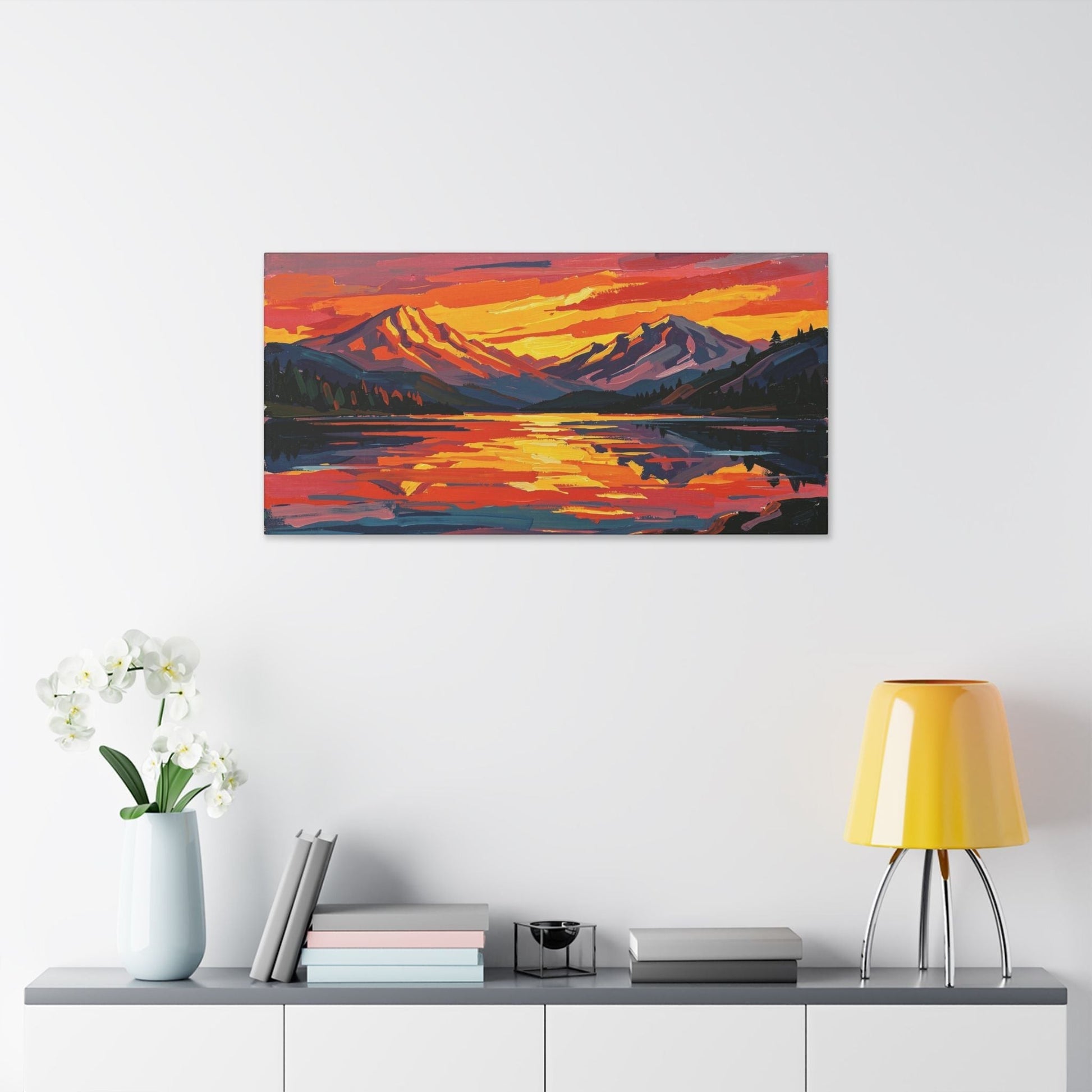 Chromatic sunset mountain lake canvas print with vibrant orange and indigo brushstrokes hanging on a white wall.