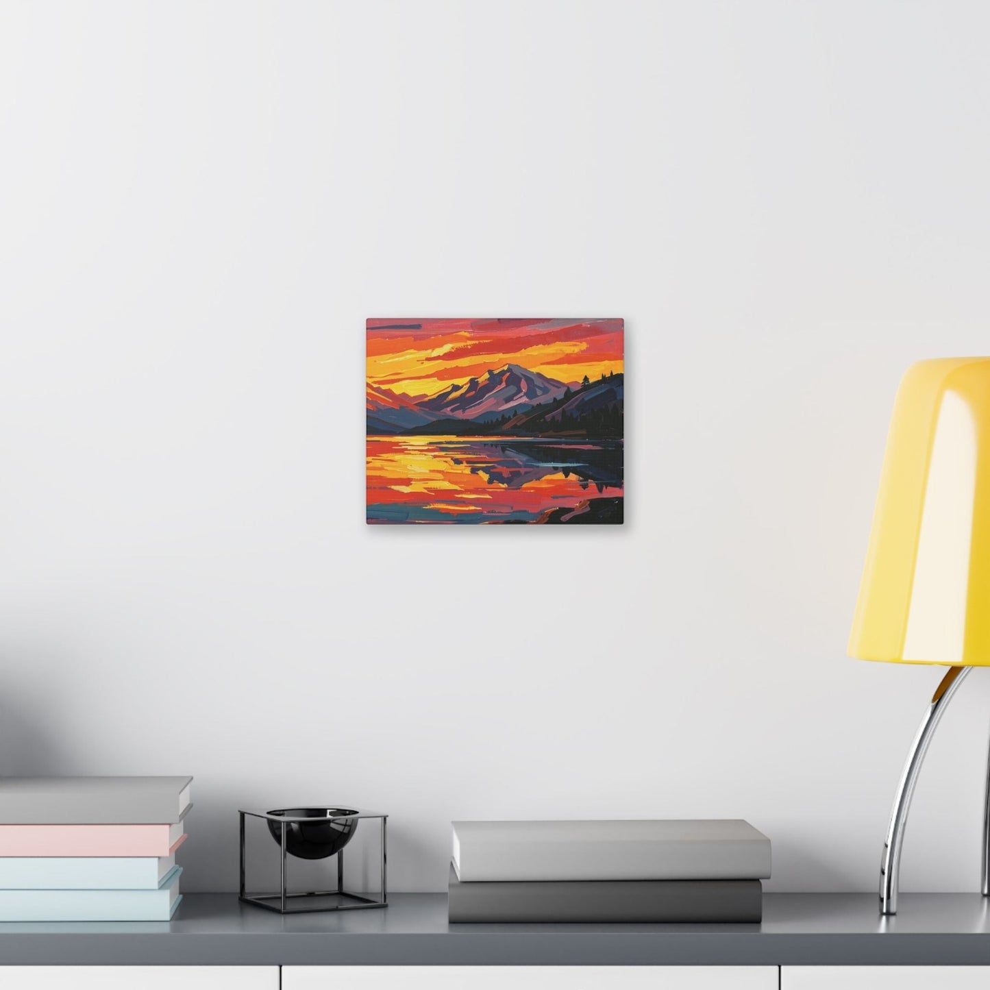 Chromatic canvas print of a vibrant mountain lake sunset with orange and indigo brushstrokes on a white wall.