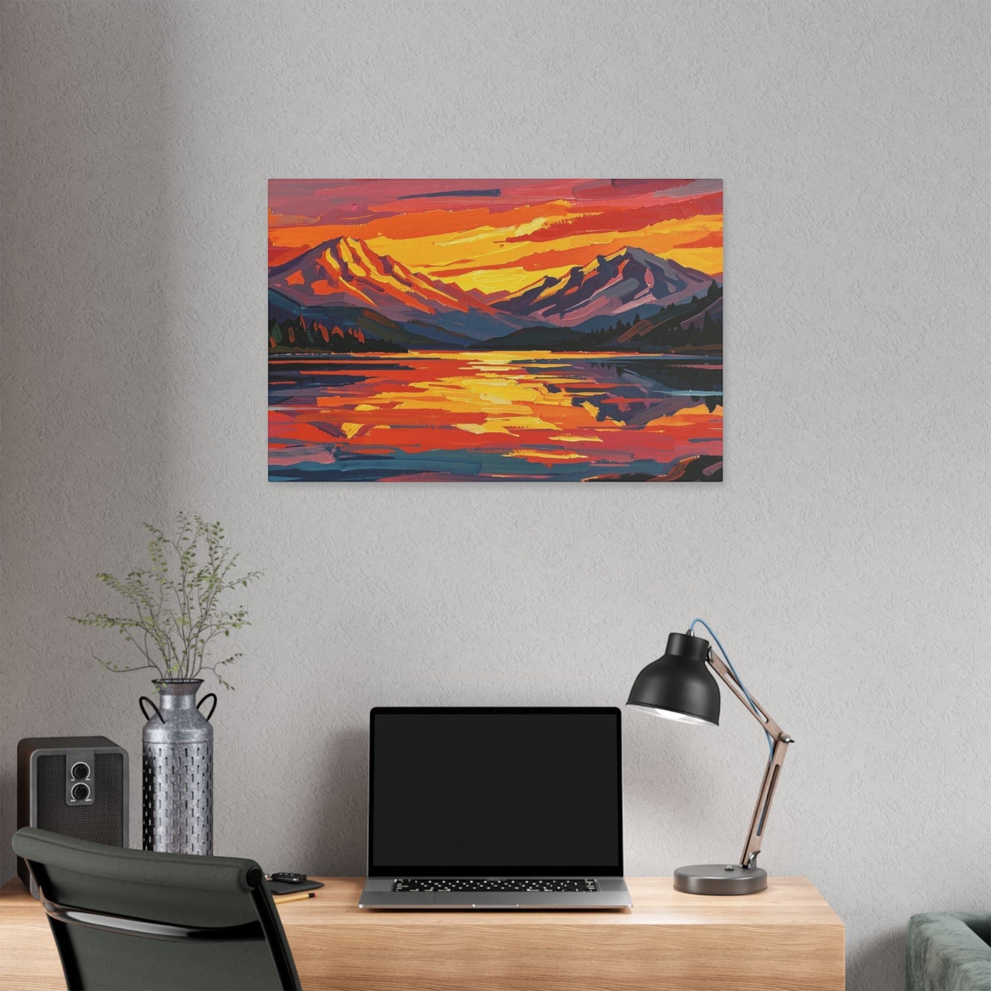 Chromatic sunset mountain lake canvas print with vibrant orange and indigo brushstrokes hanging above a desk.