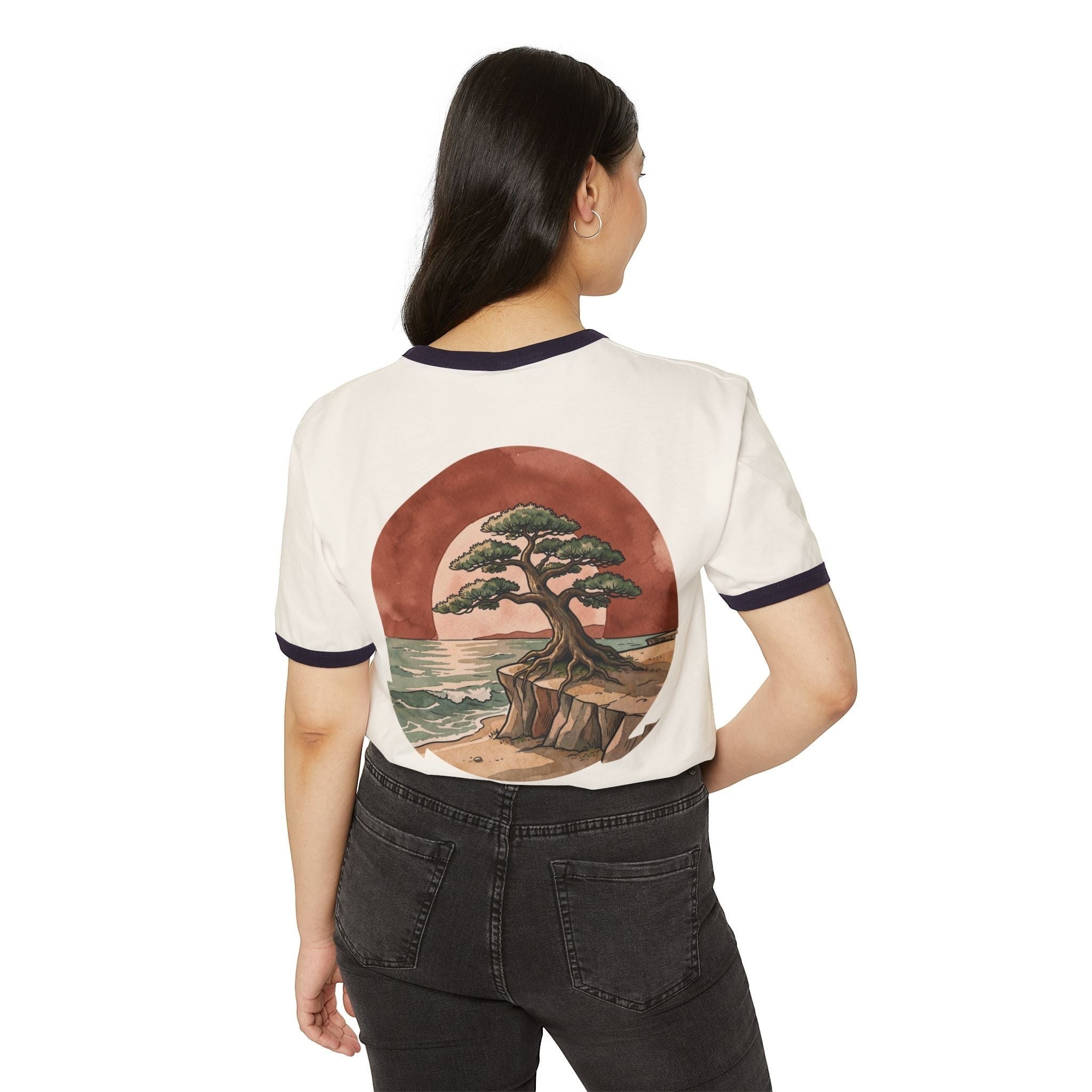 Woman wearing a Chromatic retro ringer tee with a bonsai tree and ocean sunset graphic on the back.